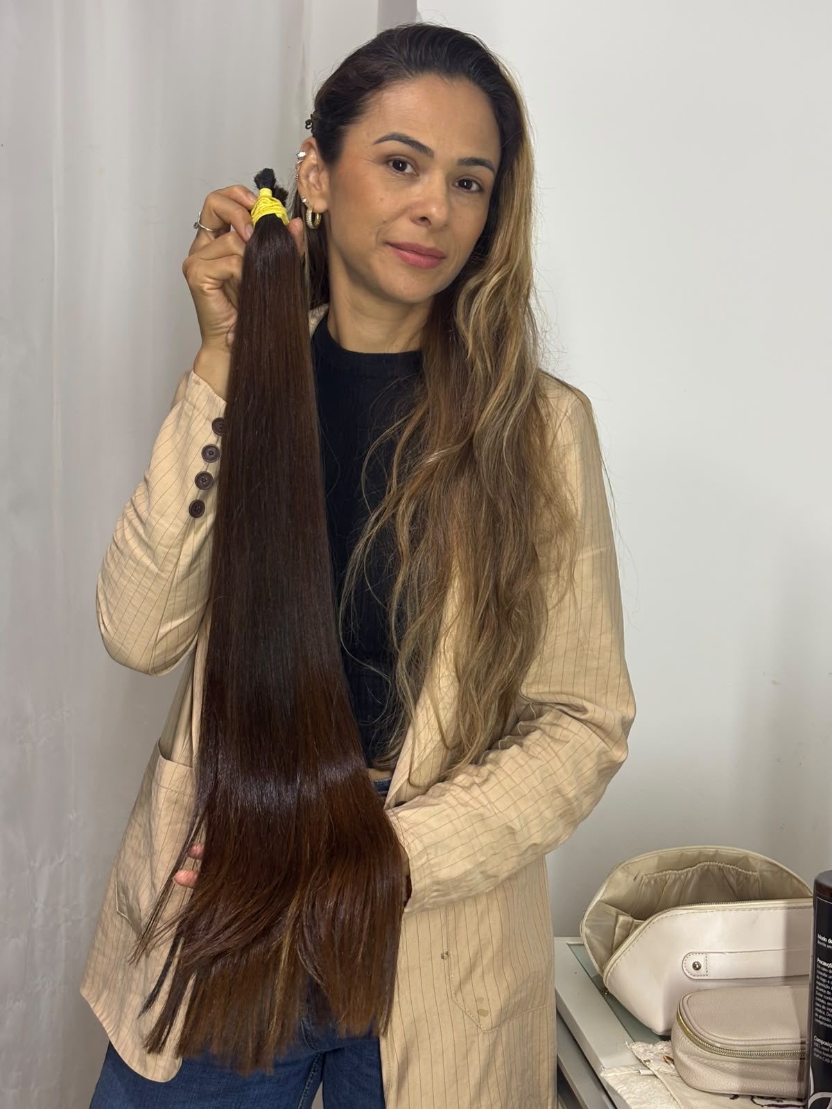 Profissional do Espaço Mega Hair segurando mecha de cabelo natural